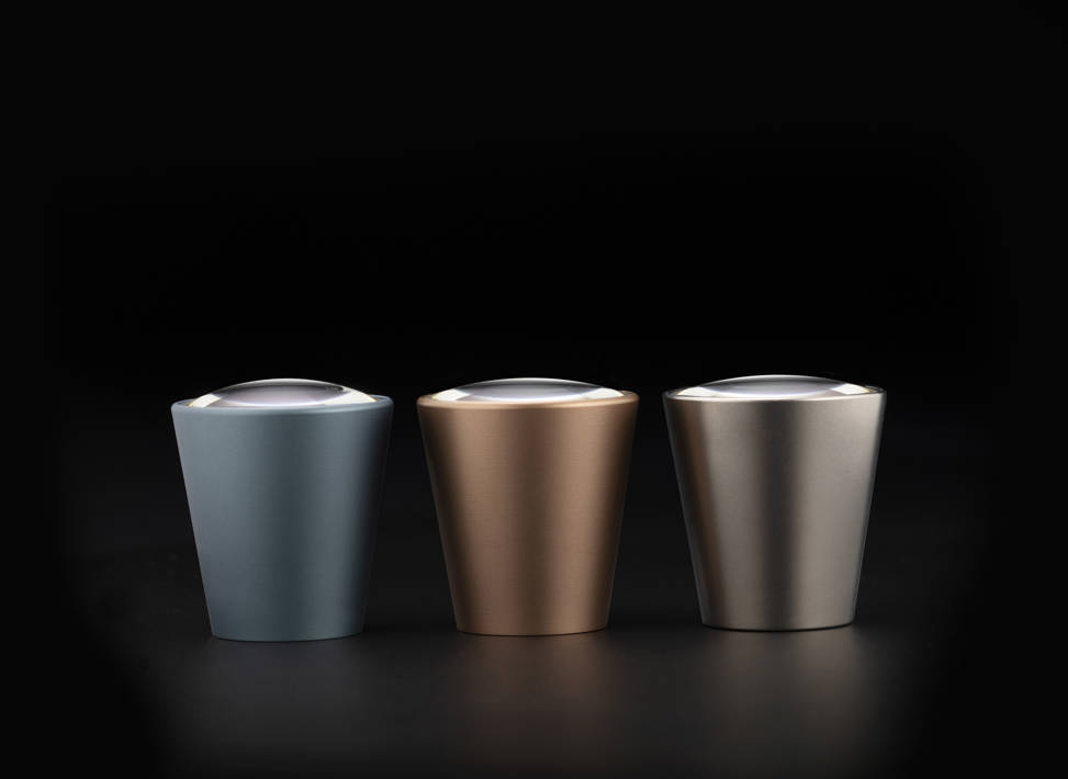 Three Galilean HD Coloured Oculars in colours (from left to right): Blue Slate, Rose Gold and Lunar Grey, placed on the black background